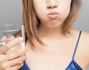 Woman rinsing out her mouth with water